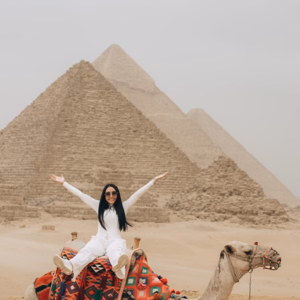 Tourist riding a camel at the Giza Pyramids during a day trip from El Gouna by plane