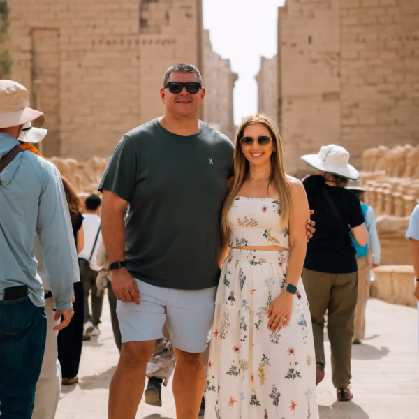 Tourists posing at Karnak Temple in Luxor between ancient stone columns