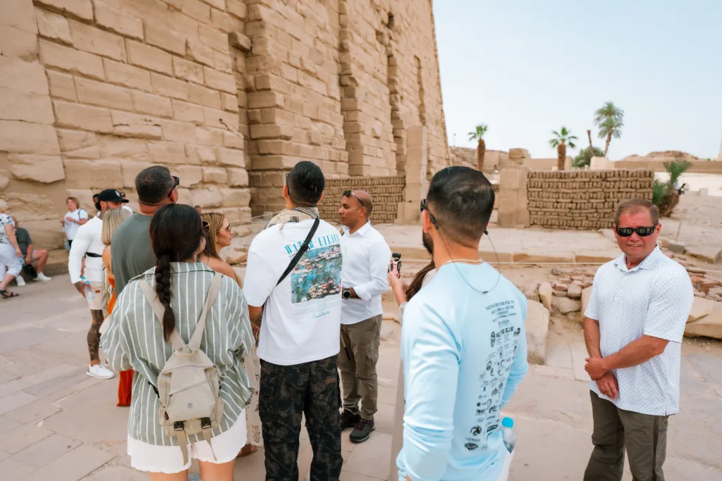 Egyptologist tour guide explaining Karnak Temple to visitors in Luxor, Egypt