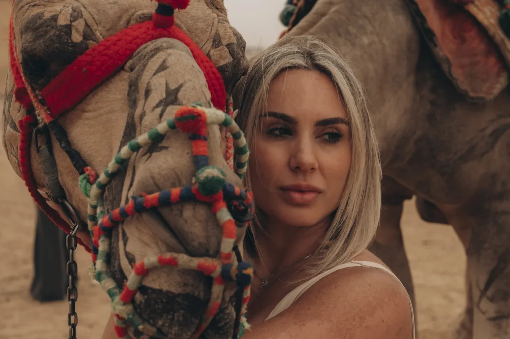 posing with a decorated camel near the Giza Pyramids