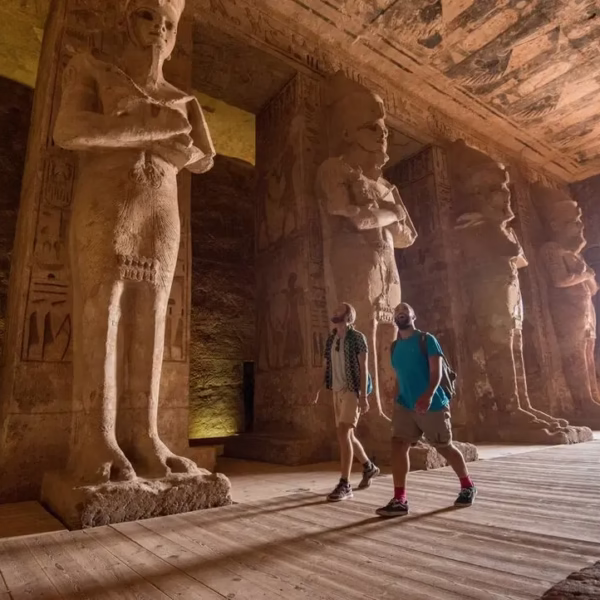 Tourists exploring the monumental statues inside the ancient Abu Simbel Temple.