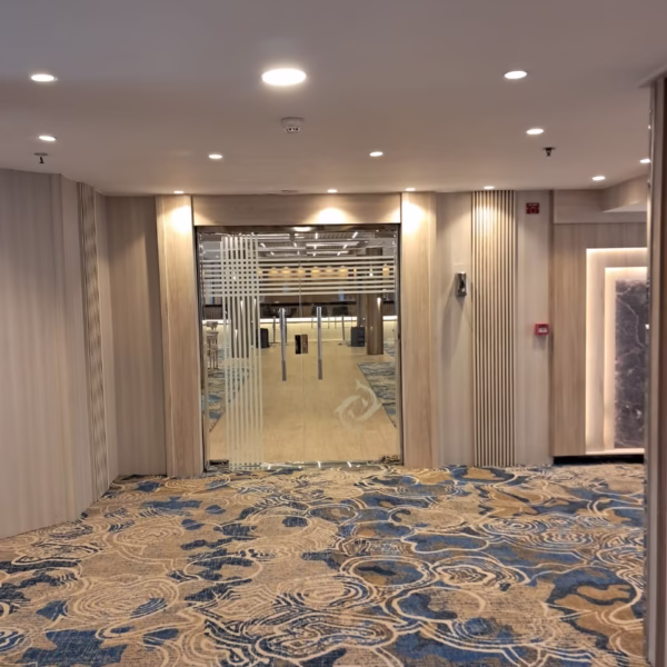 Modern Nile cruise entrance with glass doors, wave-patterned carpet, and warm lighting for a luxury Egypt river tour.