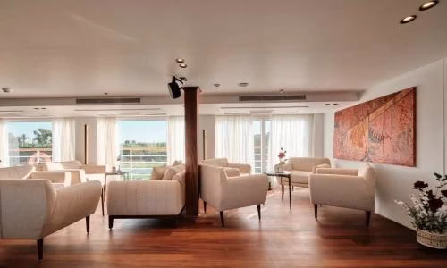 Modern lounge with cream sofas and large windows on a luxury Nile cruise ship for a premium Egypt travel experience.