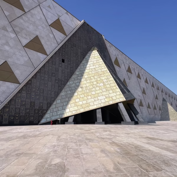 Modern geometric facade of the Grand Egyptian Museum featuring triangular motifs for an iconic Egypt travel experience.