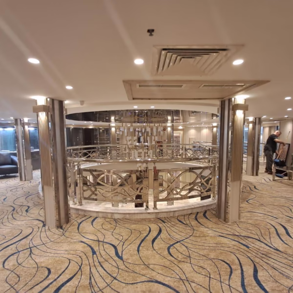 Luxury Nile cruise upper deck lobby with patterned carpets, metallic railings, and view of the grand marble atrium.