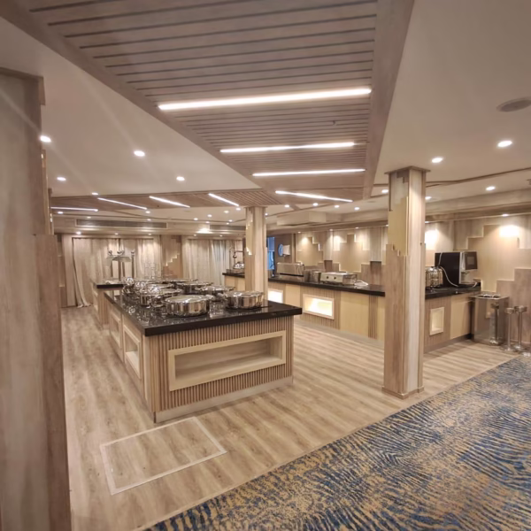 Modern Nile cruise buffet with silver chafing dishes and elegant lighting for a luxury Egyptian dining experience.