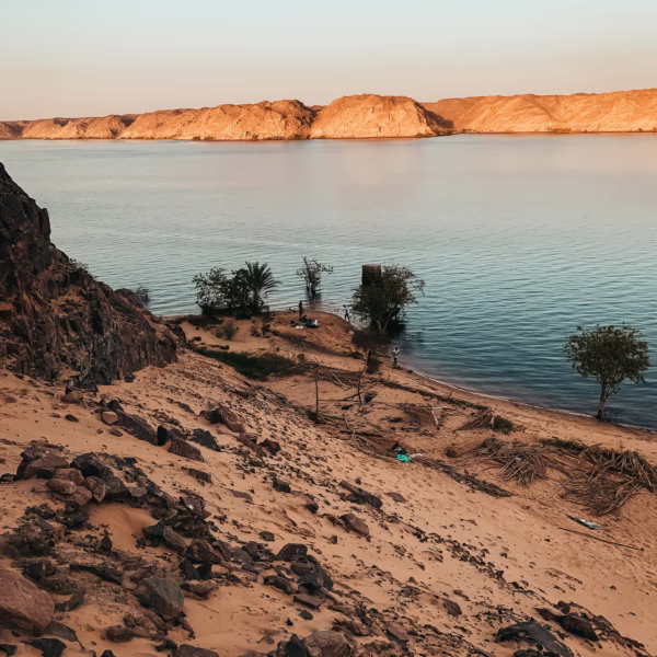 Sandy banks of the Nile River in Aswan with golden hills, a serene natural landscape for Egypt travel.