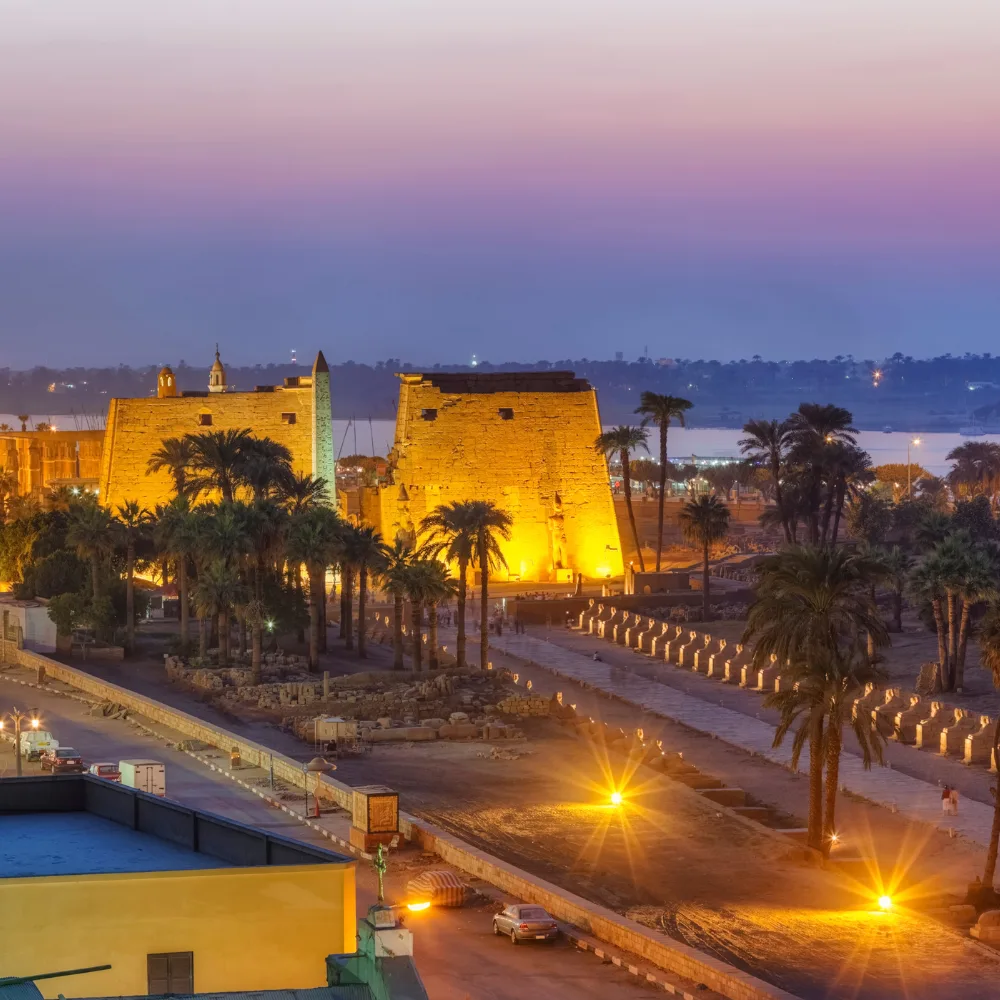 Illuminated Luxor Temple and obelisk at sunset